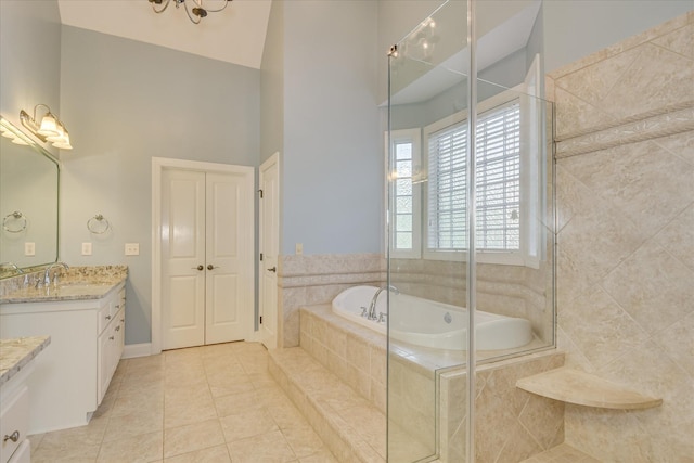 full bath with tile patterned floors, vanity, a garden tub, a towering ceiling, and a tile shower