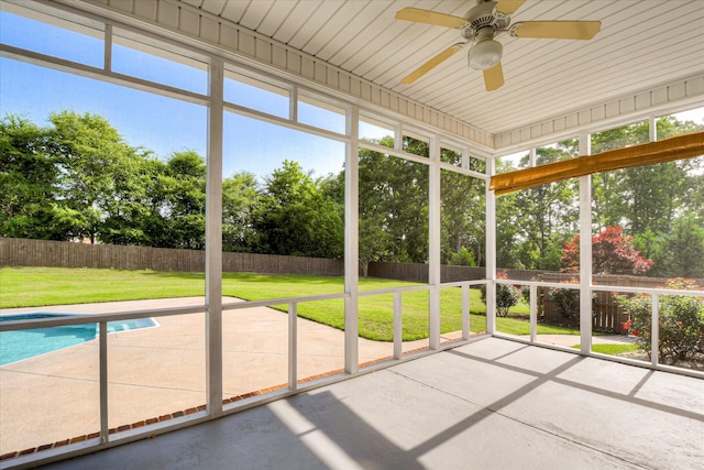 unfurnished sunroom featuring a ceiling fan