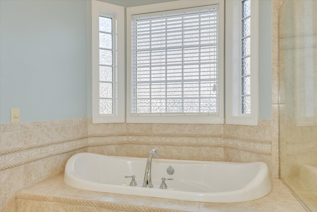 bathroom featuring plenty of natural light and a bath