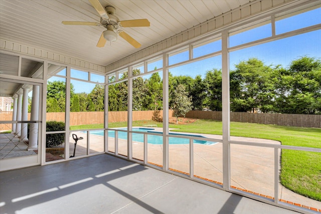 unfurnished sunroom with a hot tub, a ceiling fan, and healthy amount of natural light
