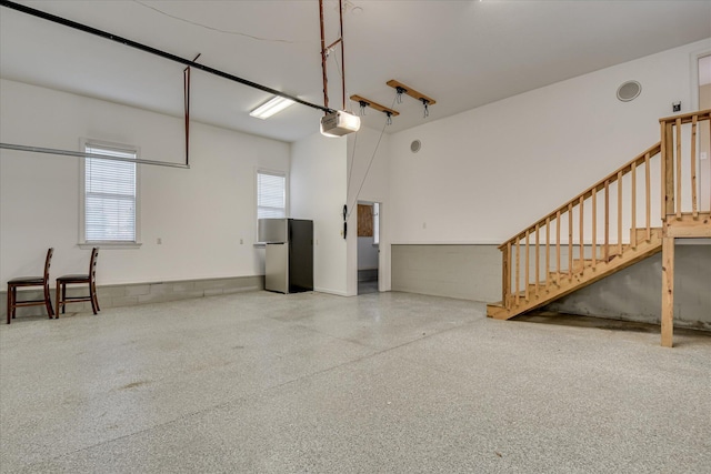 garage with freestanding refrigerator and a garage door opener