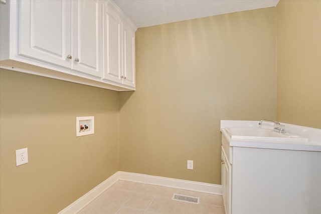 washroom with hookup for a washing machine, cabinet space, baseboards, and light tile patterned flooring