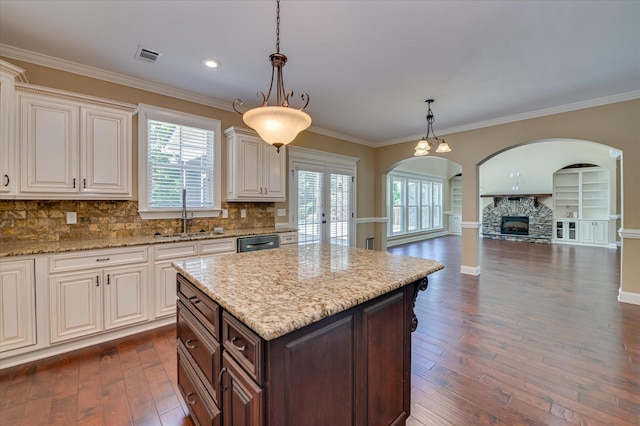 1164 Waltons Pass, Evans, GA 30809 - kitchen with arched walkways, healthy amount of natural light, stainless steel dishwasher, dark wood finished floors, and ornamental molding