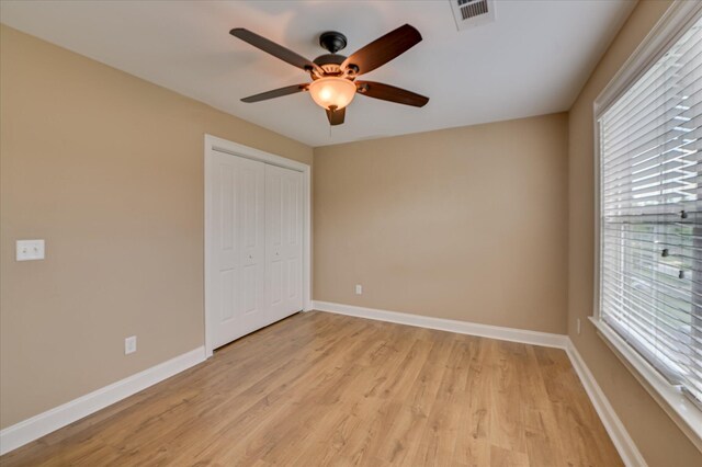 1164 Waltons Pass, Evans, GA 30809 - unfurnished bedroom with multiple windows, light wood-type flooring, a closet, and ceiling fan