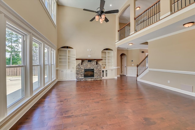 1164 Waltons Pass, Evans, GA 30809 - unfurnished living room featuring a towering ceiling, a fireplace, a ceiling fan, dark wood-style floors, and built in shelves