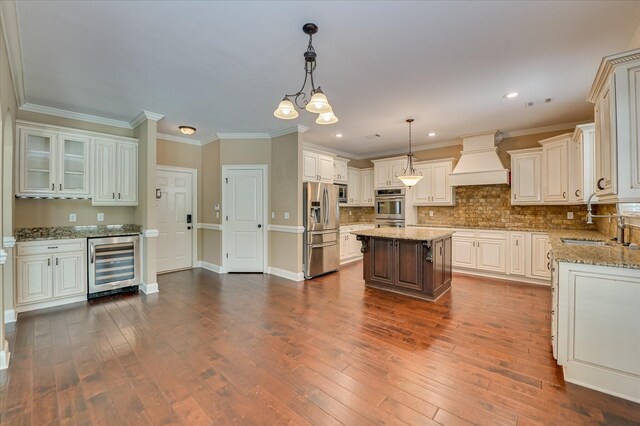 1164 Waltons Pass, Evans, GA 30809 - kitchen with wine cooler, stainless steel appliances, custom range hood, dark wood finished floors, and light stone countertops