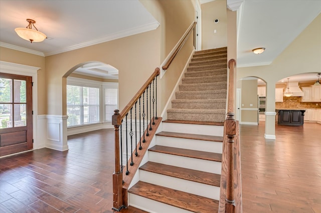 1164 Waltons Pass, Evans, GA 30809 - entryway with arched walkways, dark wood-type flooring, stairway, crown molding, and a wainscoted wall
