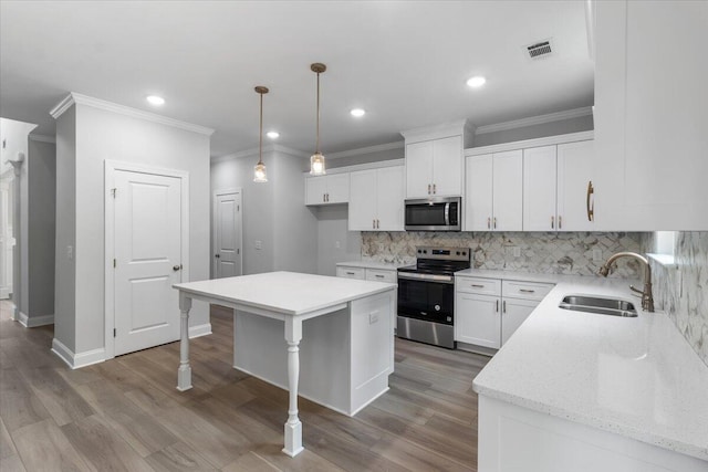 5085 Anna Way Unit Fb28, North Augusta, SC 29841 - kitchen featuring appliances with stainless steel finishes, backsplash, a kitchen bar, white cabinetry, and light wood-type flooring