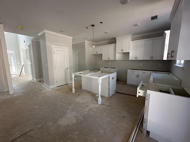 kitchen with a healthy amount of sunlight, a kitchen island, white cabinets, and crown molding