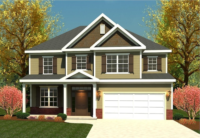craftsman house with driveway, an attached garage, brick siding, and a front yard