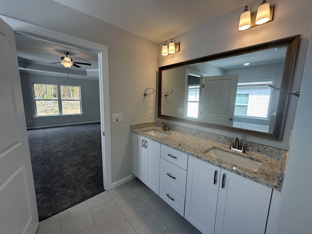 full bath with baseboards, double vanity, a sink, and a ceiling fan