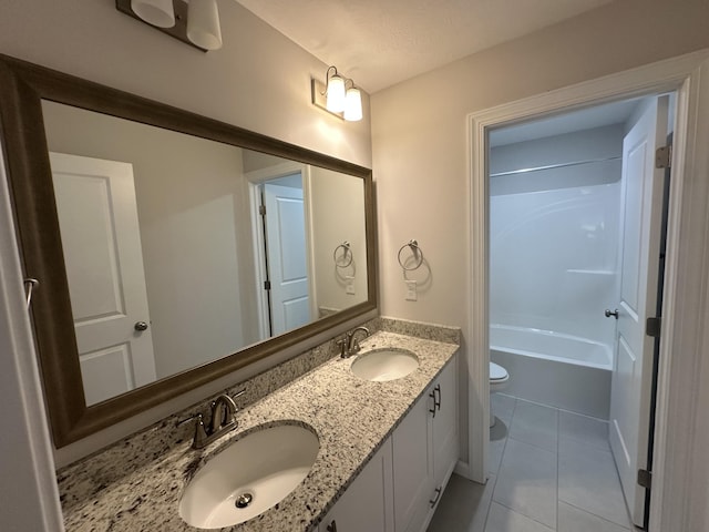 full bathroom with toilet, a sink, double vanity, and tile patterned flooring
