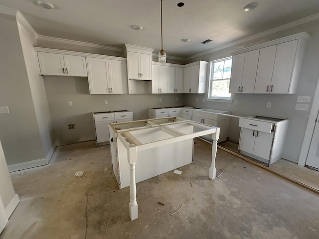 kitchen with ornamental molding, visible vents, a kitchen island, and white cabinetry