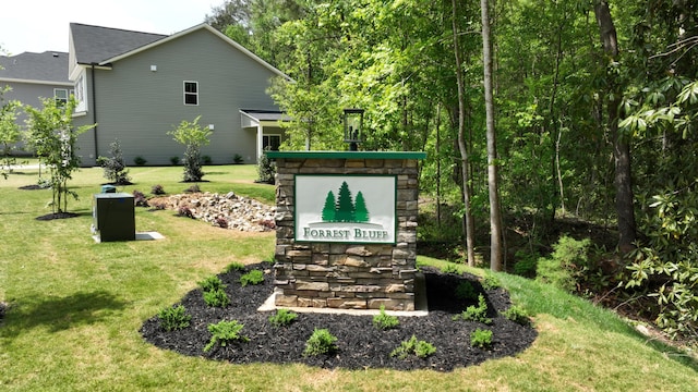 community / neighborhood sign featuring a yard