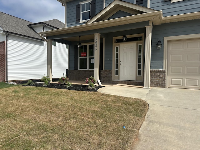 view of exterior entry featuring covered porch, a garage, and brick siding