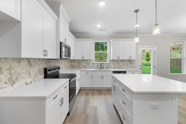 5085 Anna Way Unit Fb28, North Augusta, SC 29841 - kitchen featuring stainless steel appliances, white cabinets, a center island, crown molding, and light wood-style floors
