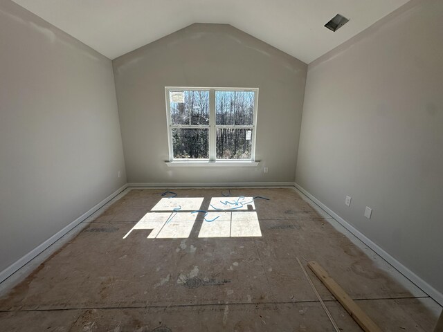 unfurnished room featuring vaulted ceiling