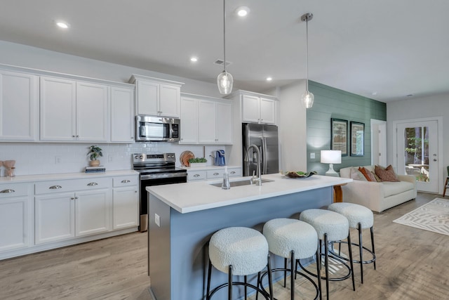 778 Count Fleet Ct, Graniteville, SC 29829 - kitchen with white cabinetry, stainless steel appliances, a breakfast bar, a center island with sink, and a sink