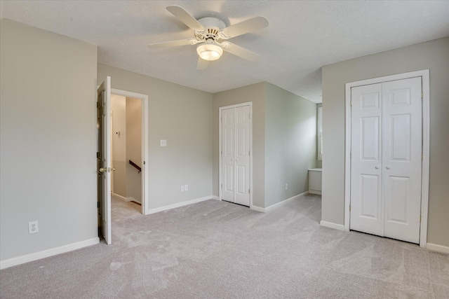 81 Two Mile Dr, Johnston, SC 29832 - unfurnished bedroom featuring two closets, light carpet, a textured ceiling, and ceiling fan