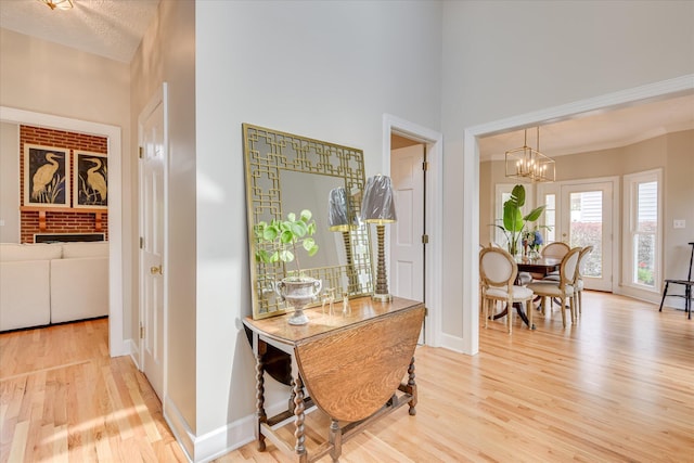 81 Two Mile Dr, Johnston, SC 29832 - dining area with light wood-type flooring, a chandelier, a towering ceiling, and a brick fireplace