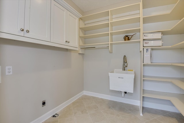 81 Two Mile Dr, Johnston, SC 29832 - laundry area featuring hookup for an electric dryer, cabinet space, and light tile patterned floors