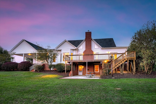 81 Two Mile Dr, Johnston, SC 29832 - back of house at dusk featuring stairs, a wooden deck, a chimney, a patio area, and a yard