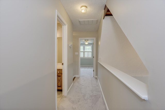 81 Two Mile Dr, Johnston, SC 29832 - hallway featuring light colored carpet, a textured ceiling, and an upstairs landing