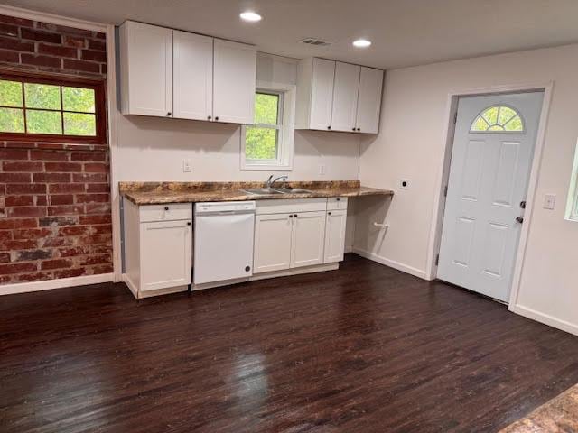 kitchen featuring white dishwasher, baseboards, dark wood-style floors, and a sink