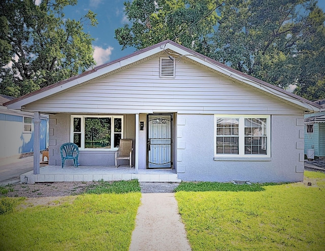 1431 Perry St, Augusta, GA 30901 - view of front of house featuring covered porch, a front yard, and stucco siding