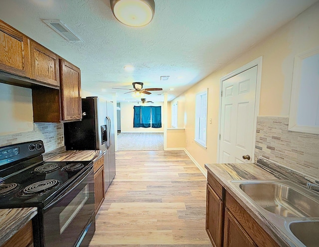 1431 Perry St, Augusta, GA 30901 - kitchen with black / electric stove, light wood finished floors, backsplash, a textured ceiling, and ceiling fan