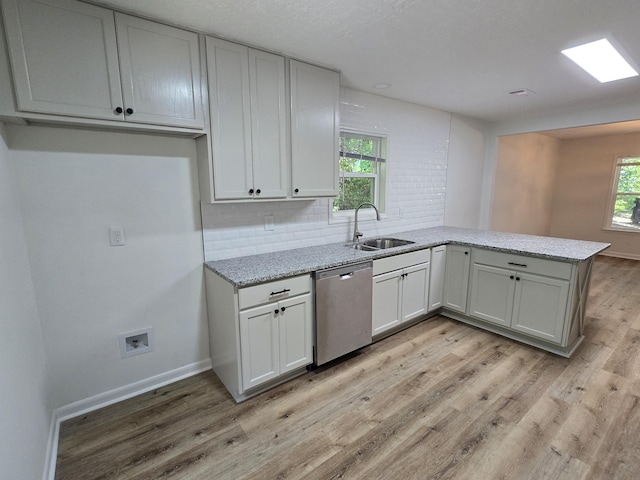 469 Lawrence Dr, Evans, GA 30809 - kitchen featuring a peninsula, light wood-style floors, stainless steel dishwasher, light stone countertops, and decorative backsplash