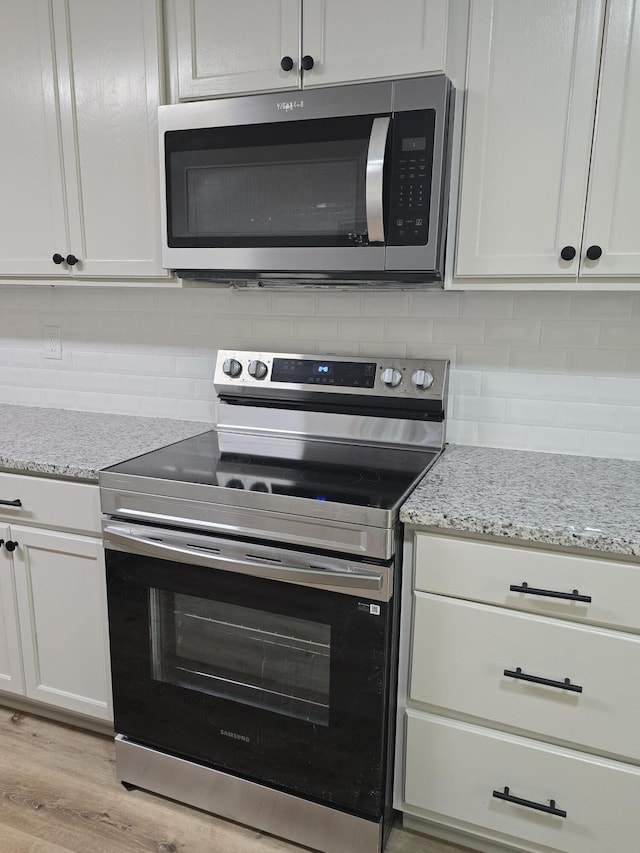 469 Lawrence Dr, Evans, GA 30809 - kitchen with appliances with stainless steel finishes, tasteful backsplash, and white cabinetry