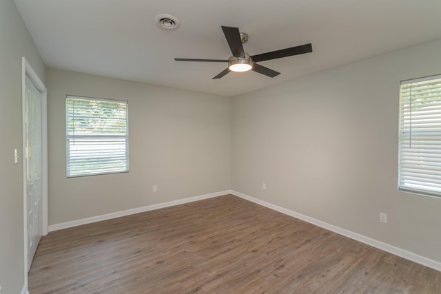 spare room with hardwood / wood-style flooring, plenty of natural light, and ceiling fan