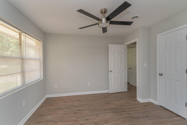 unfurnished bedroom with ceiling fan, multiple windows, and light hardwood / wood-style flooring