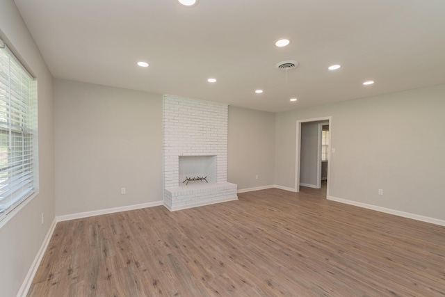 unfurnished living room featuring a fireplace and wood-type flooring