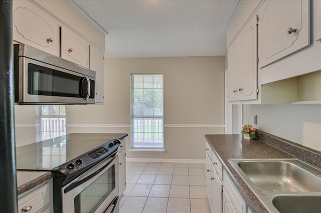 4171 Arlington Rd, Evans, GA 30809 - kitchen with appliances with stainless steel finishes, white cabinets, light tile patterned floors, and dark countertops
