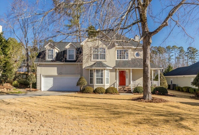 view of front facade featuring a garage, a front yard, and covered porch