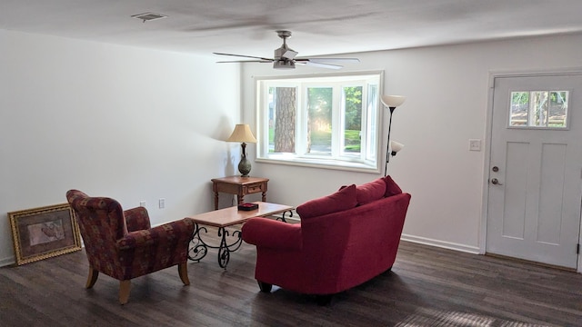 living area featuring ceiling fan and dark wood-type flooring