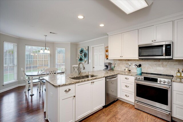 4478 Amanda Ct, Evans, GA 30809 - kitchen with appliances with stainless steel finishes, a peninsula, ornamental molding, light wood-style flooring, and white cabinets