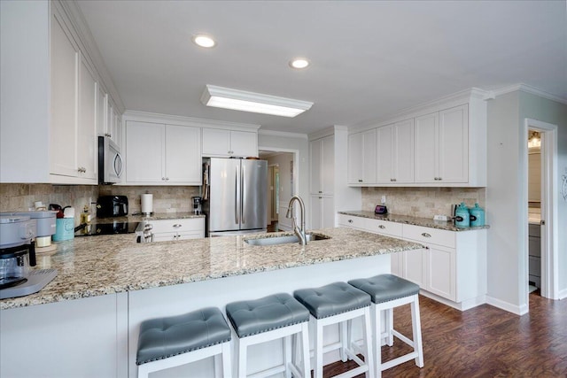 4478 Amanda Ct, Evans, GA 30809 - kitchen with appliances with stainless steel finishes, a peninsula, decorative backsplash, light stone counters, and dark wood-type flooring