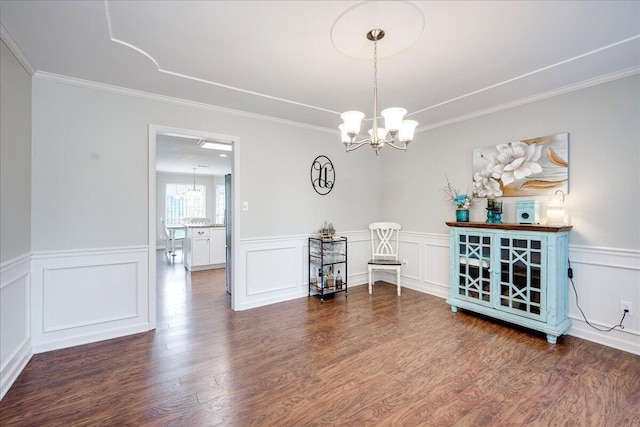 4478 Amanda Ct, Evans, GA 30809 - dining area with a chandelier, wood finished floors, crown molding, a wainscoted wall, and a decorative wall