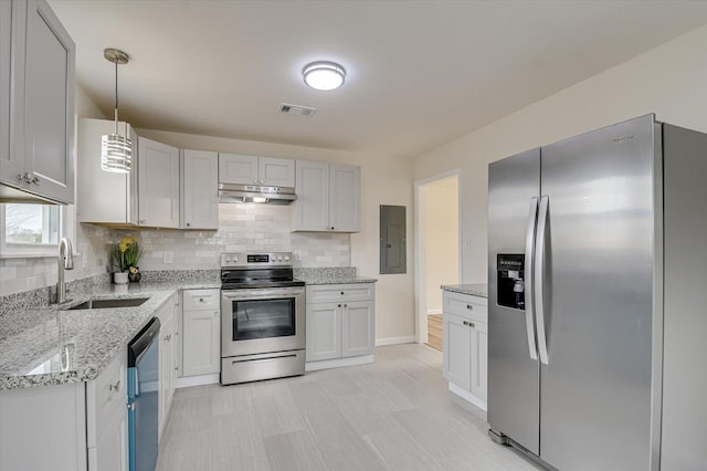 kitchen featuring sink, appliances with stainless steel finishes, electric panel, tasteful backsplash, and decorative light fixtures