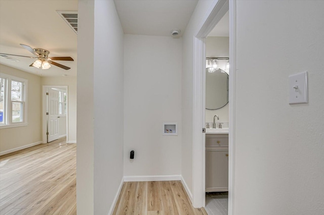 laundry area featuring ceiling fan, hookup for a washing machine, light hardwood / wood-style floors, and sink