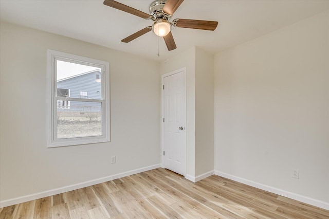 empty room with ceiling fan and light hardwood / wood-style floors