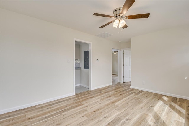 unfurnished room with ceiling fan, electric panel, and light wood-type flooring