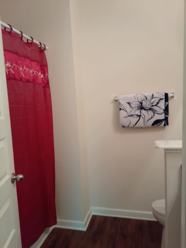 bathroom with hardwood / wood-style floors and toilet