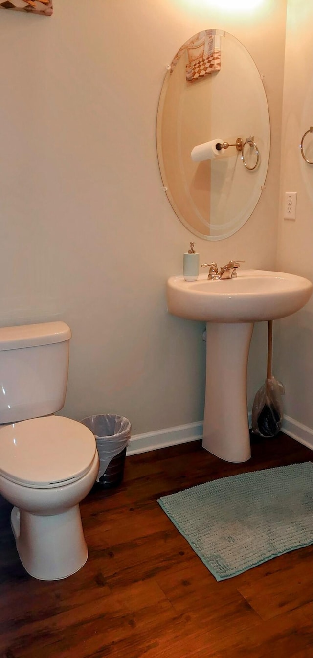 bathroom with hardwood / wood-style floors, sink, and toilet