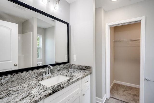 3605 Pebble Creek Dr, Hephzibah, GA 30815 - bathroom with vanity, a spacious closet, toilet, baseboards, and a shower
