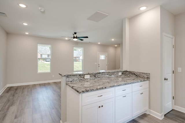 3605 Pebble Creek Dr, Hephzibah, GA 30815 - kitchen with a peninsula, light wood-style floors, light stone countertops, white cabinets, and recessed lighting