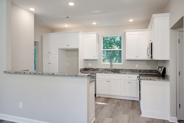 3605 Pebble Creek Dr, Hephzibah, GA 30815 - kitchen with stainless steel appliances, a sink, white cabinetry, light stone countertops, and light wood-style floors